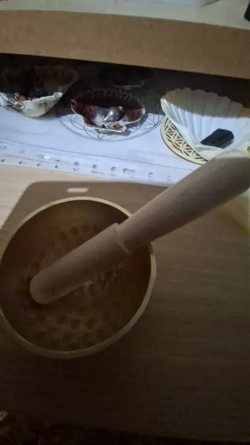 Verified buyer photo: singing bowl with the included wooden mallet standing inside, on a kitchen table