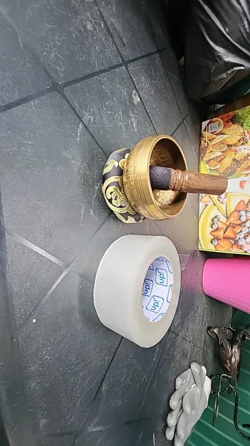 Verified buyer photo: Gold Eye engraved bowl resting on its cushion with the mallet inside, photographed on a tiled floor